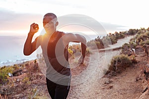 Fit young man running alone along an oceanside trail