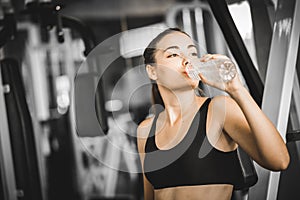 Fit young woman caucasian sitting and resting after workout or exercise in fitness gym. woman at gym