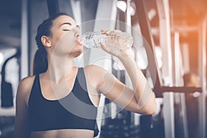 Fit young woman caucasian sitting and resting after workout or exercise in fitness gym. woman at gym taking a break and relax