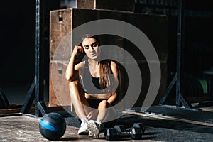 Fit young woman at a crossfit style on dark gray background.