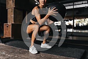 Fit young woman at a crossfit style on dark gray background.