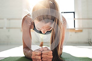 Fit young woman doing plank workout to improve her abs. Female in the gym doing crossfit photo