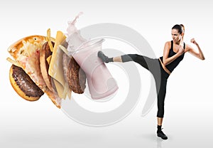 Fit young woman fighting off fast food