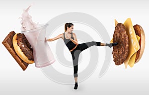 Fit young woman fighting off fast food