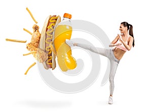 Fit young woman fighting off soda and junk food