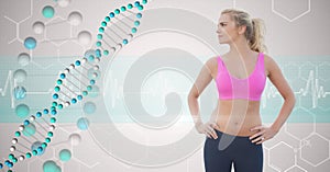 Fit young woman with hands on hips looking at DNA structure