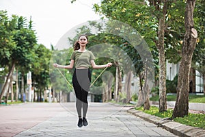 Fit young woman with jump rope in a park