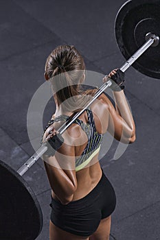 Fit young woman lifting barbell