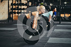 Fit young woman lifting weights during a gym class