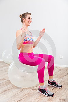 Fit young woman practicing yoga on pilates ball