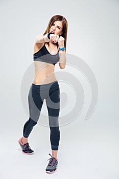 Fit young woman punching towards camera