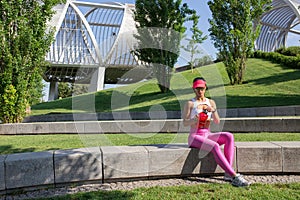 Fit young woman resting after training in park