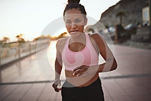 Fit young woman running on a promenade in the morning