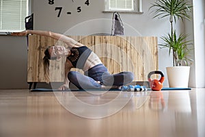 Fit young woman in sport clothes sitting in lotus position and stretching