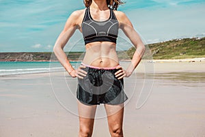 Fit young woman with toned abs on beach