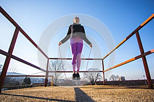 fit young woman using jump rope