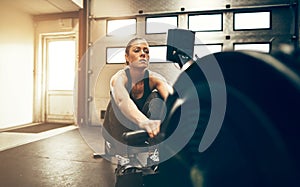 Fit young woman using a rowing machine at the gym