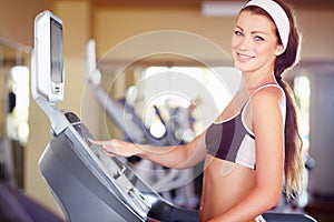 A fit young woman using the treadmill at gym