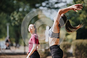 Fit young women playing and having fun in a sunny park, throwing a rugby ball. Outdoor workout in nature. Sports and