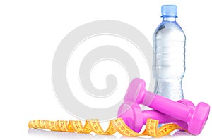 Fitnes symbols - pink dumbbells, a bottle of water and a towel. The concept of a healthy lifestyle