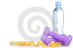 Fitnes symbols - pink dumbbells, a bottle of water and a towel. The concept of a healthy lifestyle