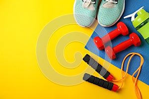 Fitness accessories on yellow background, top view