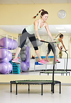 Fitness activity. Woman jumping on trampoline