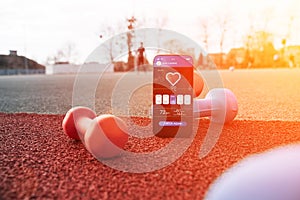 Fitness app. Smart phone screen with fitness health or sport gym mobile application on dumbbell background. App for