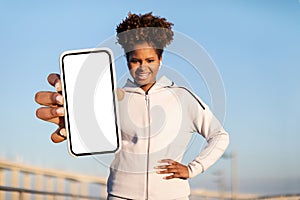 Fitness App. Sporty Black Woman Showing Big Blank Smartphone While Traning Outdoors