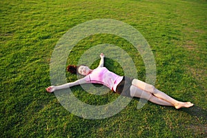 Fitness Asian Chinese woman have a rest at grass in a park