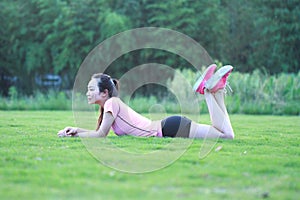 Fitness Asian Chinese woman have a rest at grass in a park