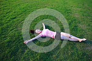 Fitness Asian Chinese woman have a rest at grass in a park