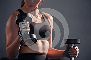 Fitness asian woman doing exercise and lifting dumbbells weights at sport gym