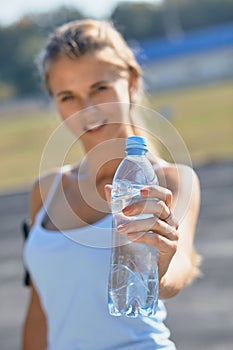 Fitness athlete woman drinking water after work out exercising on sunset evening summer in outdoor portrait