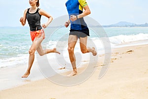 Fitness. Athletic Runners Legs Running On Beach. Exercising. Healthy Lifestyle