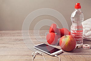 Fitness background with bottle of water, apple and smartphone