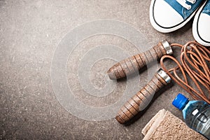 Fitness background with skipping rope, sneakers, towel and water bottle