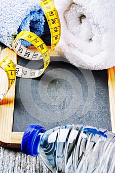 Fitness background with water bottle and towels