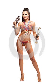 Fitness bikini athlete with winning medals