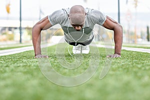 Fitness black man exercising push ups in urban background