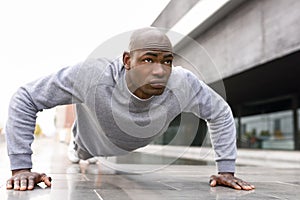 Fitness black man exercising push ups in urban background photo