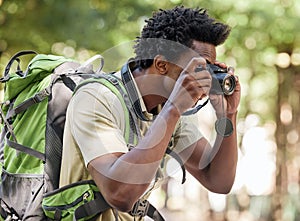 Fitness, black man and hiking with camera, forest and tourism in nature, capture moment and wilderness. African American