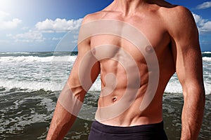 Fitness body abdominal with sea behind photo