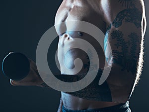 Fitness, body and man with dumbbell in hand on blue background, isolated neon blue light and muscular chest. Sports