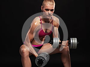 Fitness bodybuilder woman with dumbbells.beautiful blonde girl with muscles
