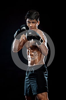 Fitness and boxing concept. Boxer, man fighting or posing in gloves on black background. Individual sports recreation.