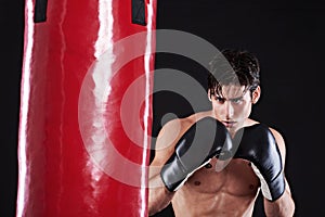 Fitness, boxing or man with punching bag in studio for exercise, challenge or competition training. Power, muscle or