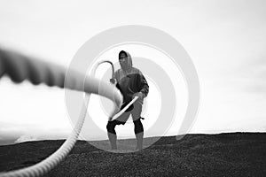 Fitness brave man doing fitness workout at beach. Black and white color