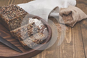 Fitness bread. A loaf of fresh rustic whole meal rye bread, sliced on a wooden board, rural food background. Top view. Copy space.