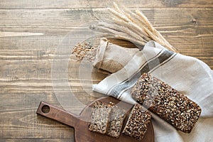 Fitness bread. A loaf of fresh rustic whole rye bread, sliced on a wooden board, rural food background. Top view. Copy space.